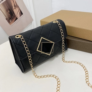 Klassische schwarze Stepptasche mit goldener Metallschnalle auf schlichtem Grund