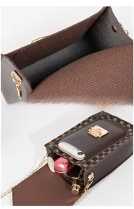 Detail view of the brown chain crossbody phone bag with dual compartments and gold lock