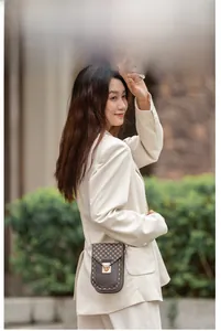 Vertical chain phone bag with retro brown print and metal buckle shown on a model