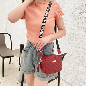 Chic burgundy quilted crossbody bag with golden metal plate and wide woven strap