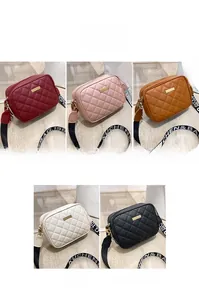 Detail view of quilted shoulder bags in red, pink, brown, white and black colors