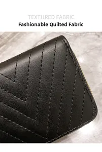Macro shot of black V-quilted faux leather wallet with premium golden zipper details
