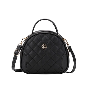 Elegant black quilted semicircular handbag with golden clover logo and crossbody strap