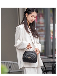 Gros plan du sac en similicuir noir matelassé avec plaque en métal doré et texture