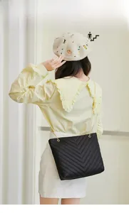 Détail du sac à bandoulière en cuir matelassé noir avec chaîne en métal dorée