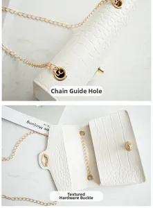 Detailed view of the gold chain guides and rotating metal lock on the white embossed bag