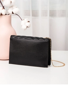 Detail view of the black crossbody bag showing V-quilted texture and gold chain strap