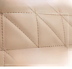 Detail of beige quilted leather with fine diamond stitching and soft glossy finish