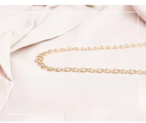 Detailed close-up of premium polished gold metal chain strap on soft fabric background