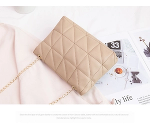 Detail of beige quilted chain bag with triangular stitching on pink silk background