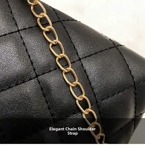 Close-up of black quilted leather texture and flexible golden chain strap on a handbag