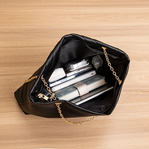 Sac fourre-tout noir matelassé avec grand espace de rangement sur table en bois