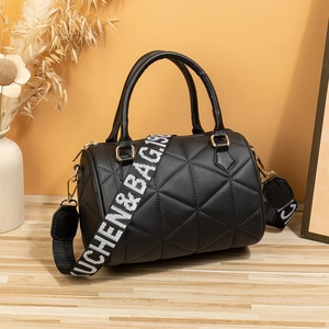 Schicke gesteppte schwarze Zylindertasche mit Goldbeschlägen und breitem Tragegurt