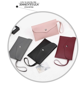 Detail of four colorful PU leather envelope clutch bags with metal snap buttons and wrist straps