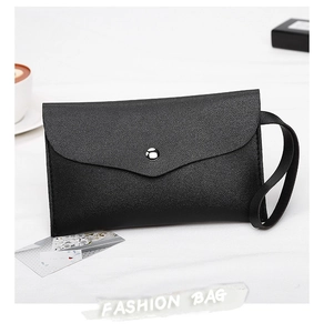 Detail of minimalist black nappa texture clutch with silver snap and wrist strap