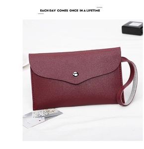 Close-up of wine red litchi texture envelope clutch bag with silver snap button