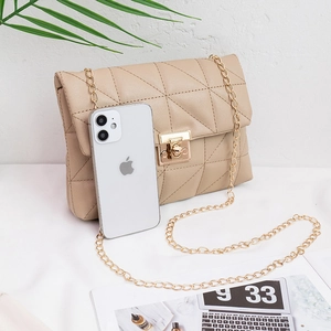 Beige quilted small square bag with gold chain strap and rotary lock shown with iPhone