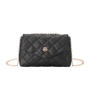 Detail of black quilted shoulder bag featuring a gold rose-shaped metal twist lock closure