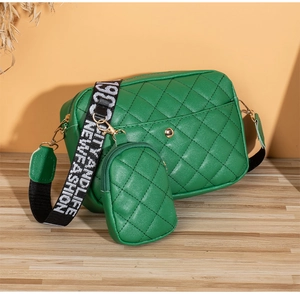 Detailed shot of green quilted crossbody bag set with wide logo strap and mini pouch