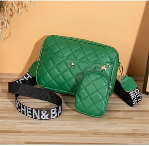 Detail of green quilted crossbody bag with matching coin purse and wide logo strap