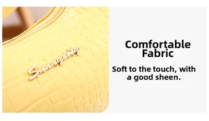 Detailed close-up of yellow crocodile texture leather and golden metal logo on the bag