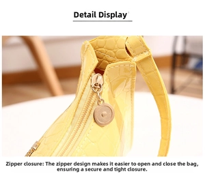 Detail of yellow crocodile pattern leather bag with golden zipper and metal charm