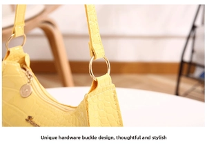 Detail of golden metal buckle and crocodile embossed leather on yellow hobo bag