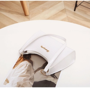 Detail of white crocodile texture HOBO bag with gold logo and metal ring hardware