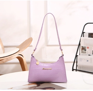 Detail of purple croc-effect faux leather underarm bag with gold zipper and metal logo