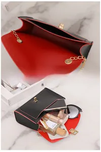 Detail of crossbody bag interior with contrasting red lining and daily essentials