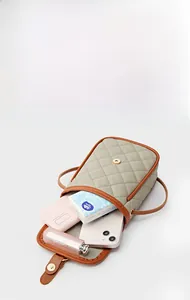Top view of olive green quilted crossbody bag showing interior space for phone and makeup