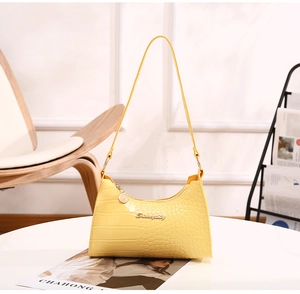 Detail of yellow crocodile-patterned hobo bag with gold hardware and logo branding