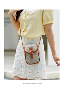 Detail of blue quilted leather phone bag with brown strap on floral lace dress