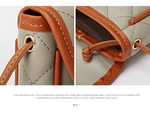 Detail of rhombic quilted stitching and grey leather with brown trim contrast texture