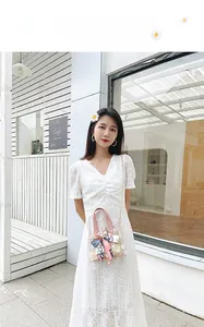 Close-up of daisy print transparent bag with pink handle and silk scarf detail