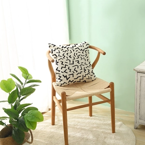 Modern black and white geometric polyester pillow case on a stylish wooden chair