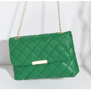 Détail du sac à bandoulière matelassé vert vif avec chaîne dorée et fermoir métallique