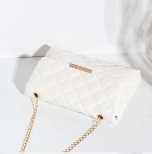 Vue détaillée du sac matelassé blanc avec fermoir en métal doré et bandoulière chaîne