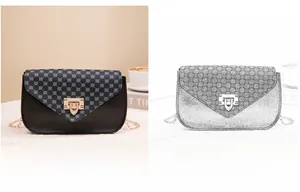 Detail of black crossbody phone bag with geometric print flap and gold metal twist lock
