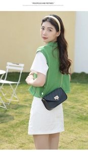 Close-up of elegant black leather crossbody bag with chain strap and gold twist lock