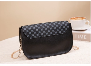 Detail of crossbody phone bag with geometric pattern flap and golden chain strap
