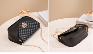 Detail of black crossbody bag with geometric grid pattern and gold rotating lock