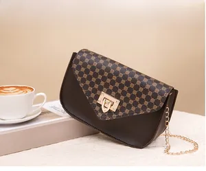 Detail of vintage brown mini crossbody bag with gold chain strap on a cafe table