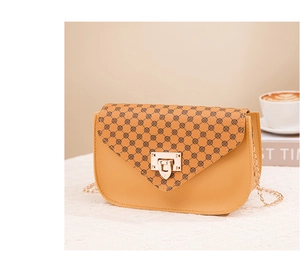 Detail of camel brown crossbody phone bag with floral pattern and gold metal lock