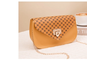 Detailed view of yellow crossbody bag with geometric patterns and gold twist lock clasp