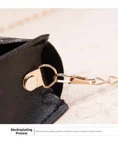 Detail of black pebbled leather mini bag featuring polished gold D-ring and chain hardware