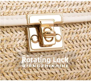 Detail shot of the golden twist-lock closure on a beige woven straw crossbody bag