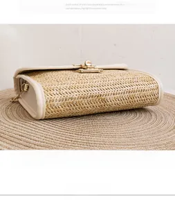 Detail shot of straw woven crossbody bag with leather trim and gold metal swivel lock