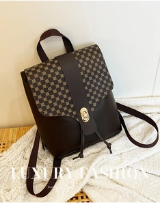 Detail of printed crossbody bag with gold twist lock and brown leather texture