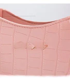 Close-up of pink crocodile texture leather with gold Sunnycity logo and plated hardware